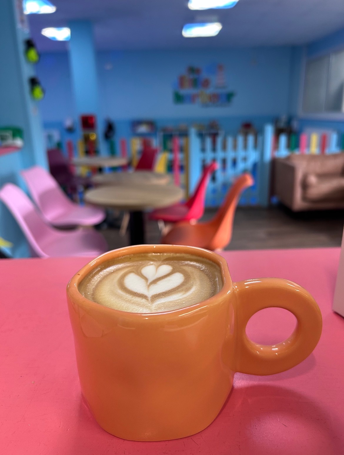 A latte in an orange cup at The Little Harbour café